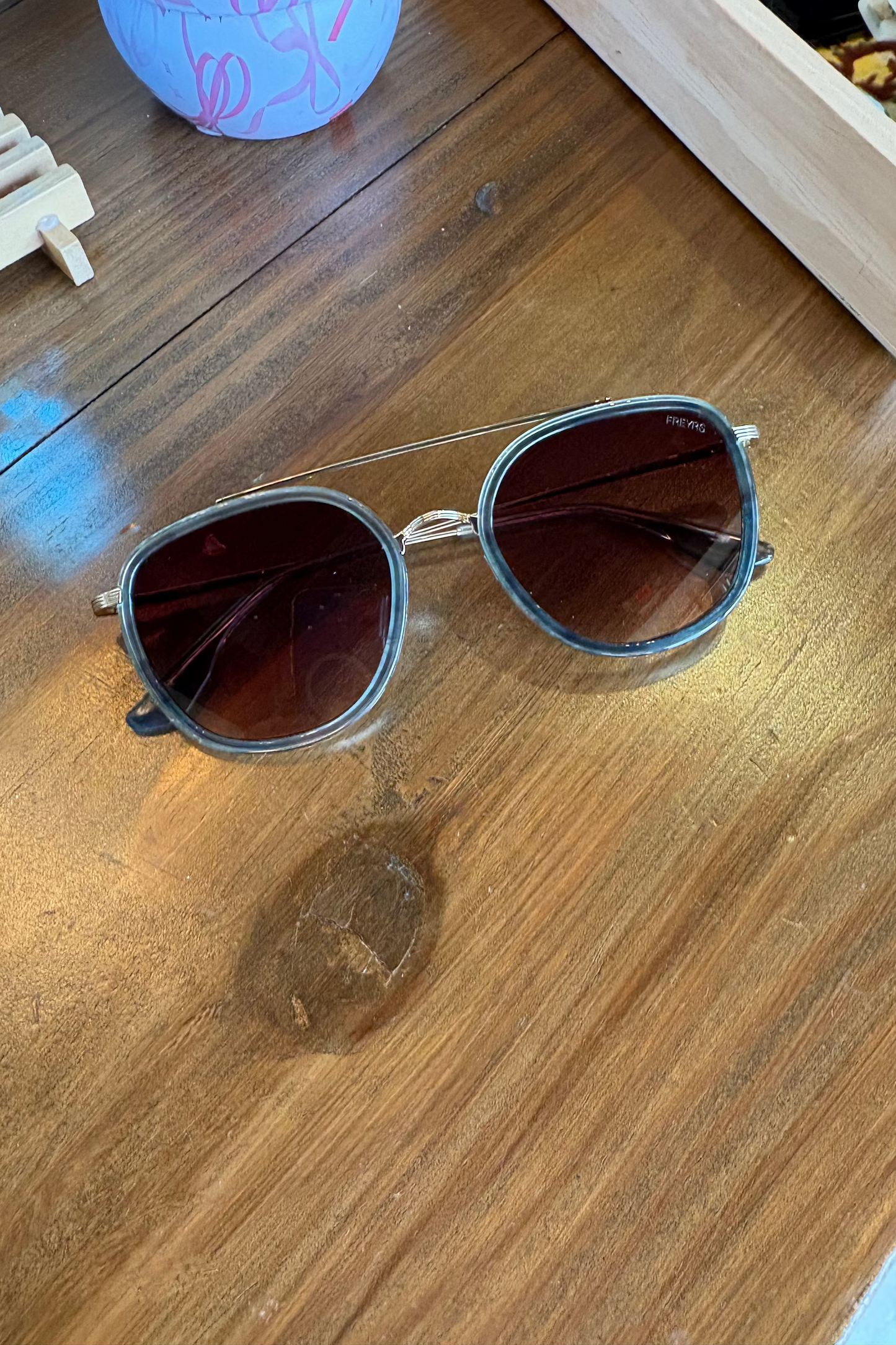 Aviator sunglasses on a wooden surface