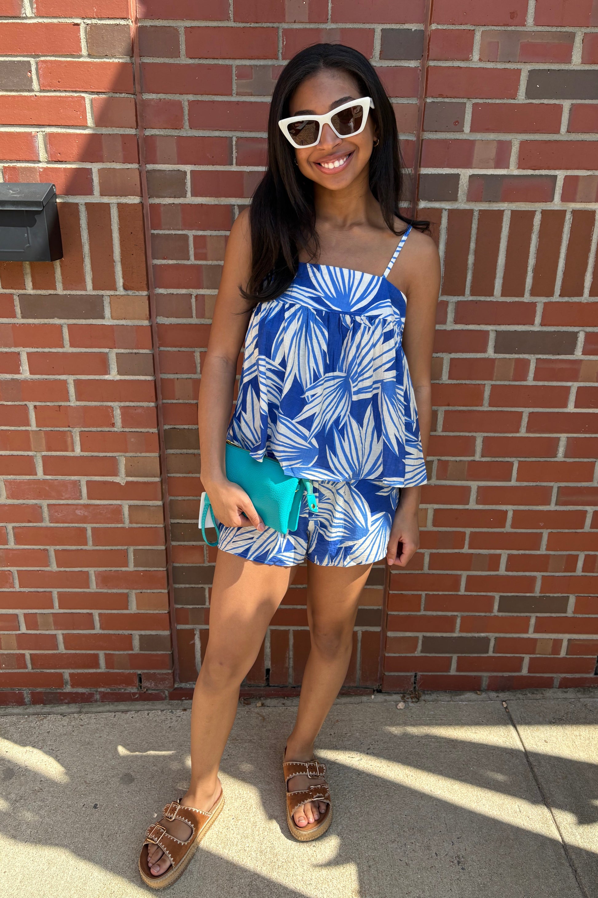 Woman in a blue and white dress standing on a brick sidewalk