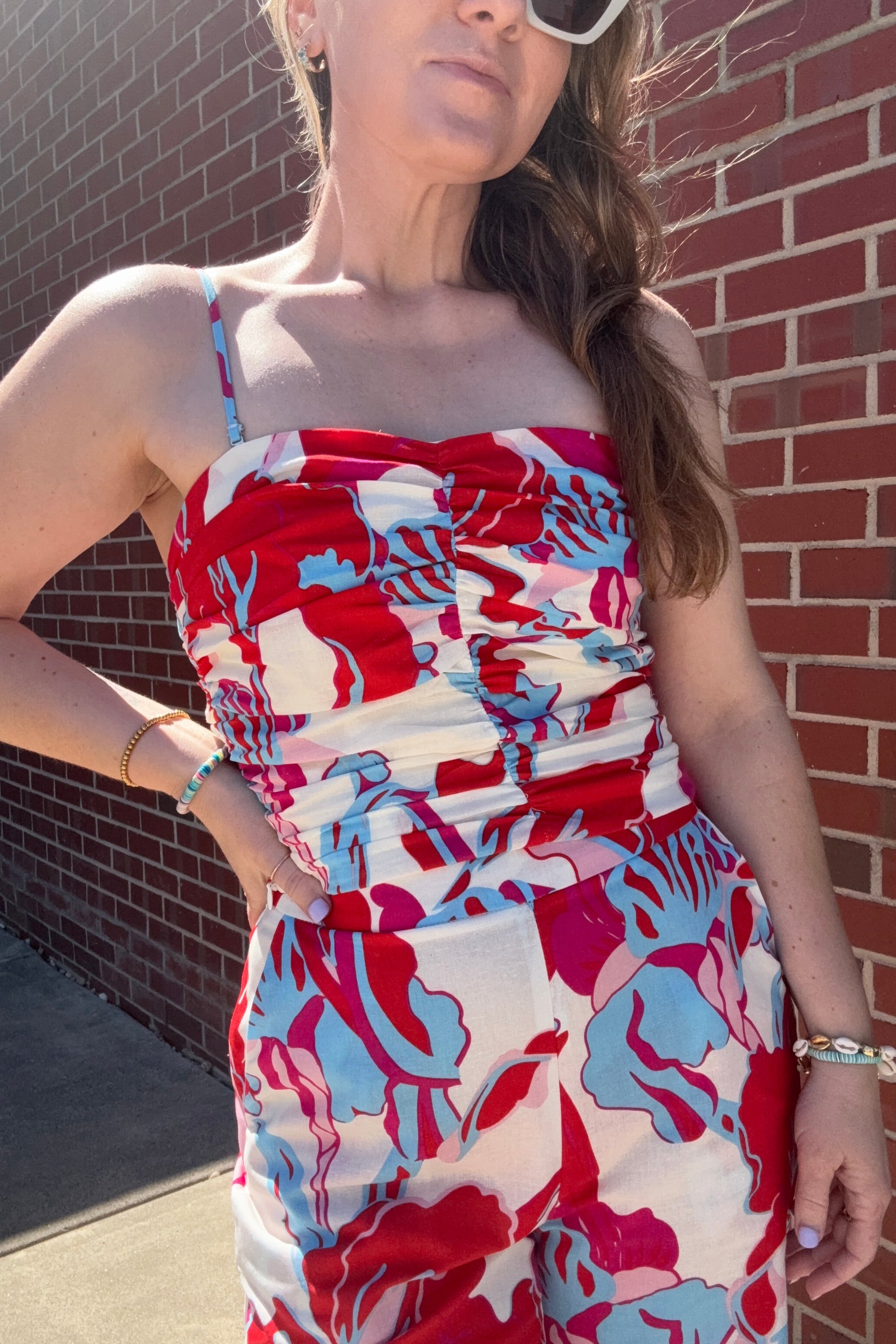 Woman lying on a brick pavement wearing a colorful dress.