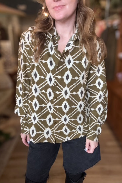 Person wearing a patterned shirt in an indoor setting