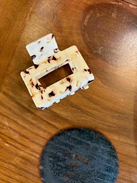 Decorative letter 'D' with tortoiseshell pattern on a wooden surface
