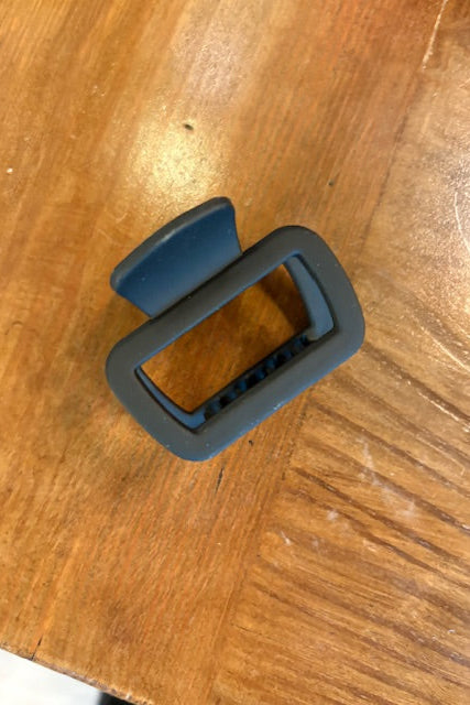 Black and blue plastic clip on a wooden surface