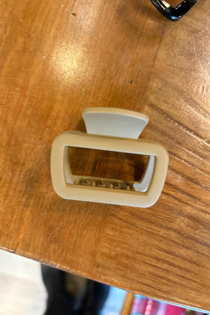 Beige plastic clip on a wooden surface