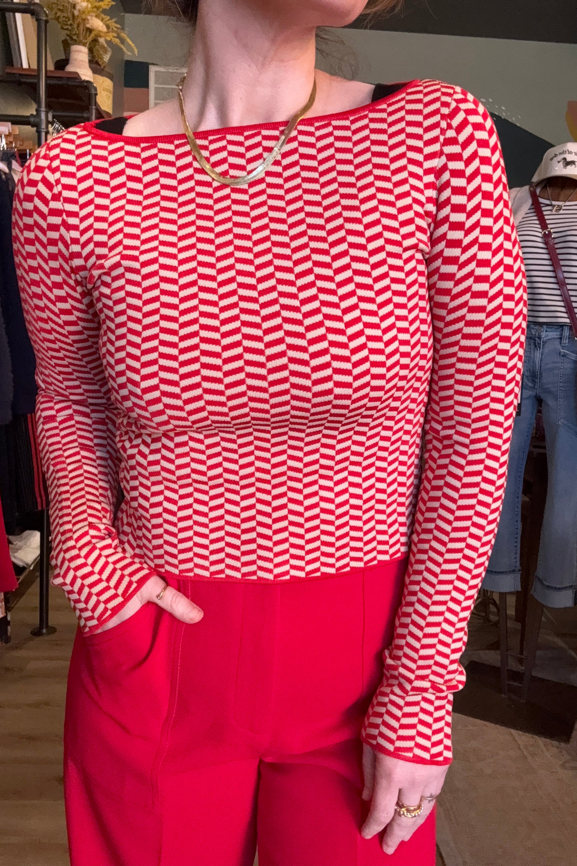 Person wearing a red and white checkered shirt with a red jacket.