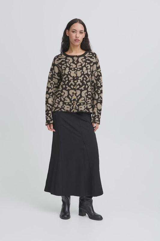 Woman wearing a patterned sweater and black skirt on a white background
