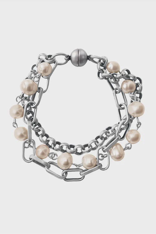 Bracelet with pearls and chain design on a light gray background