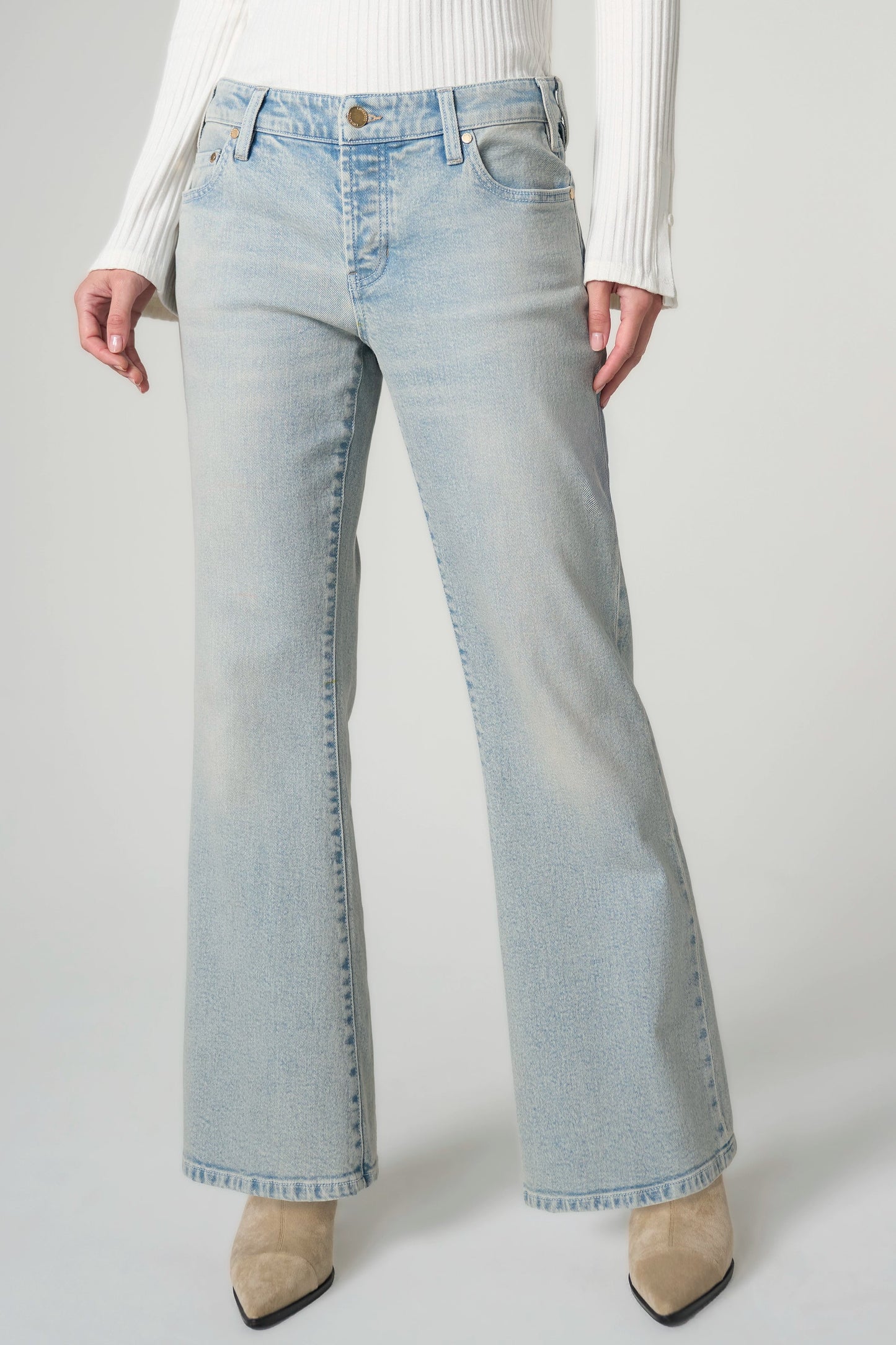Light blue jeans worn by a person on a plain background