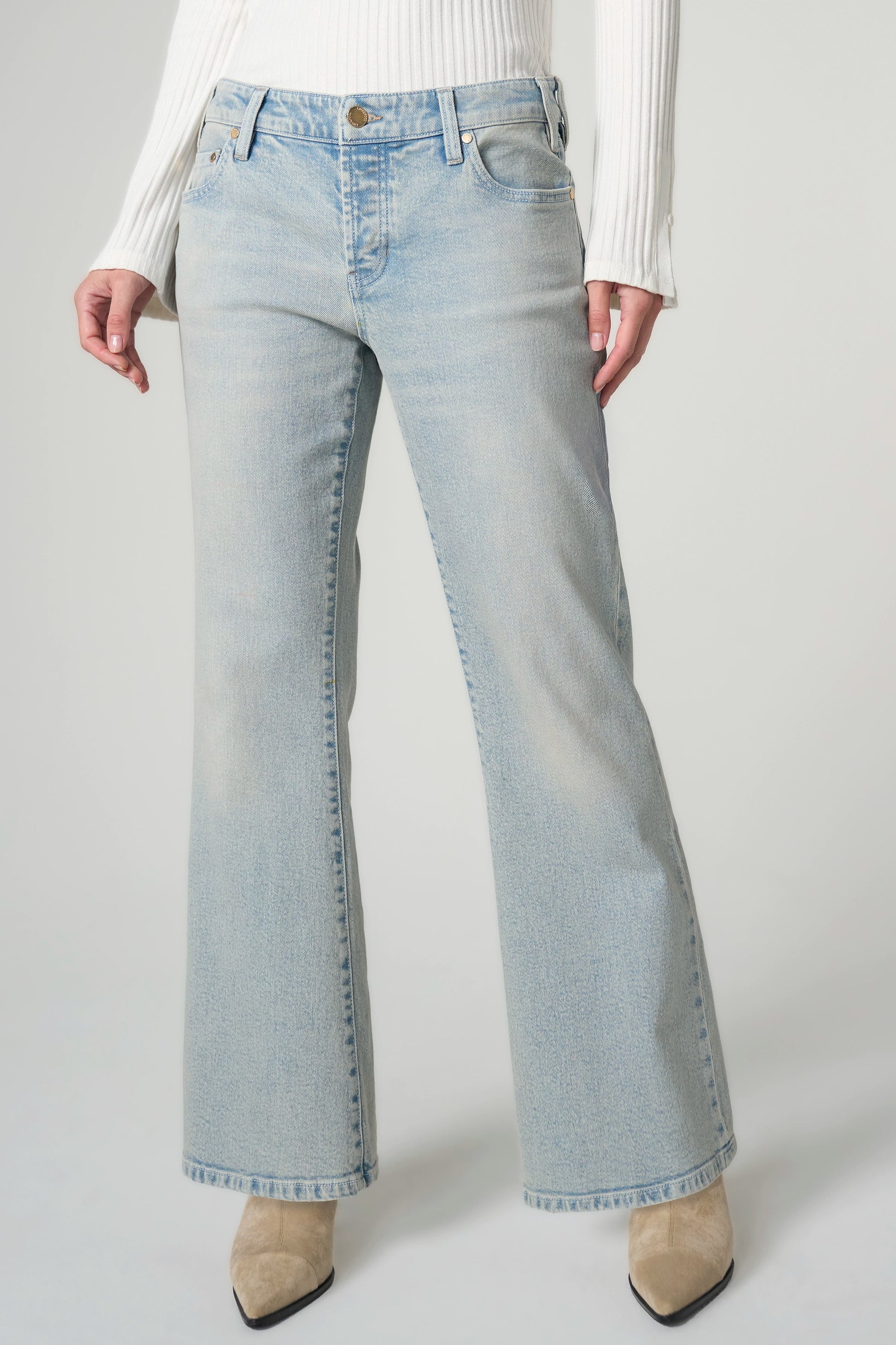 Light blue jeans worn by a person on a plain background