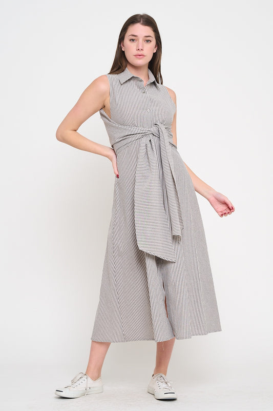 Woman wearing a sleeveless, striped dress with a belt on a white background