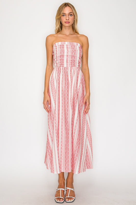 Woman wearing a strapless red and white patterned dress on a white background