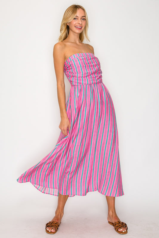 Woman wearing a pink and blue striped dress on a white background
