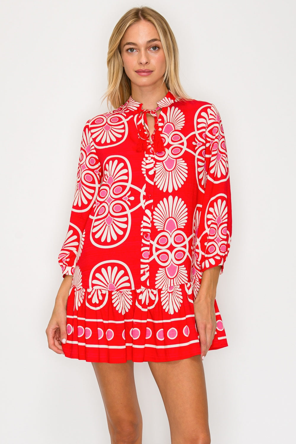 Woman wearing a red dress with white floral patterns on a white background