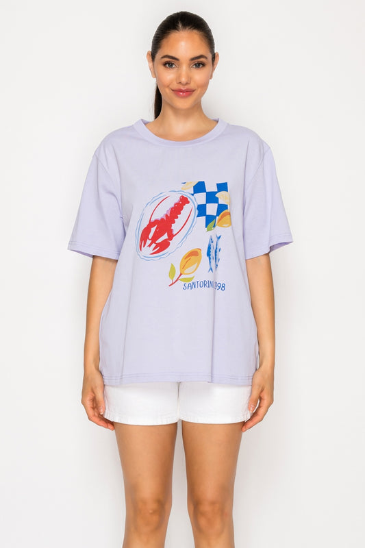 Woman wearing a light purple t-shirt with colorful graphics on a white background