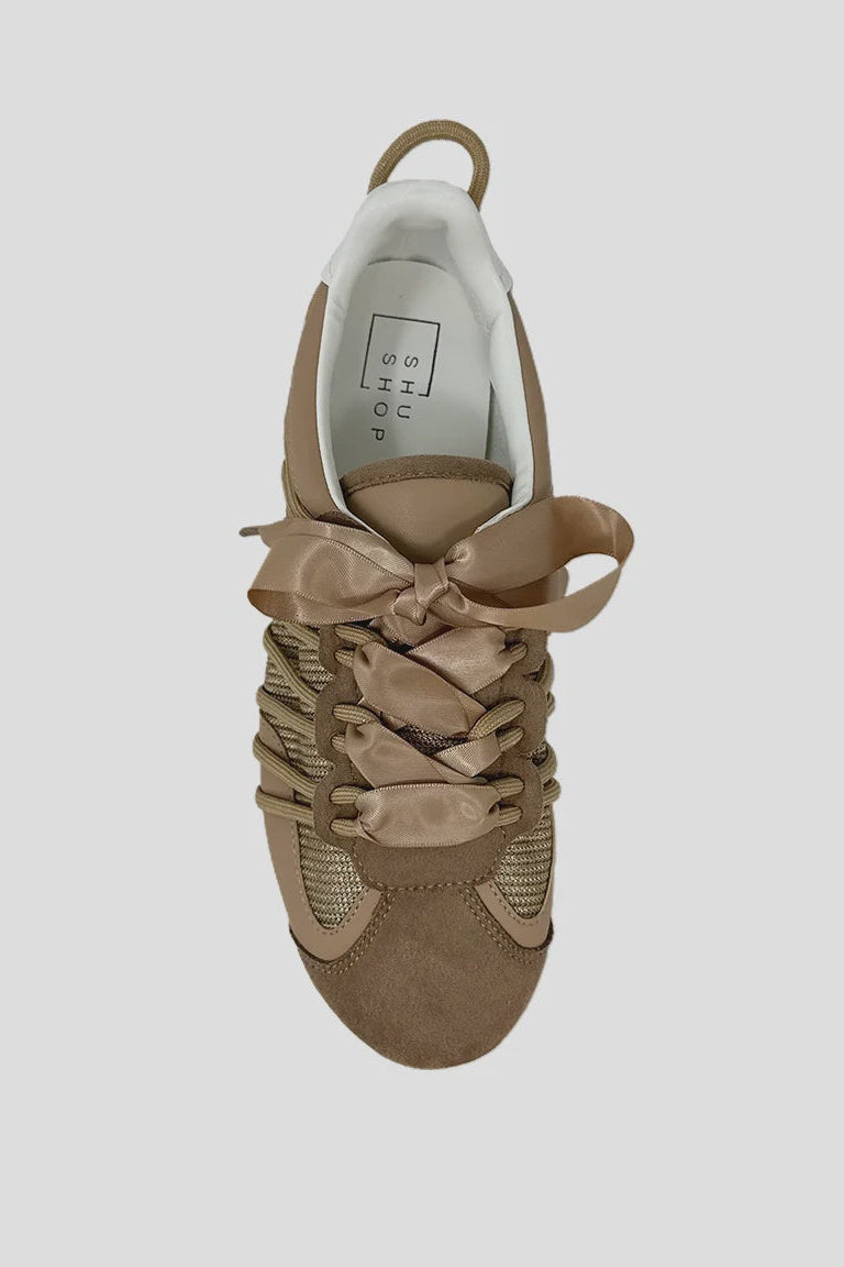 Beige sneaker with a bow on a light gray background