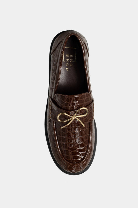 Brown leather loafer with gold lace on a white background