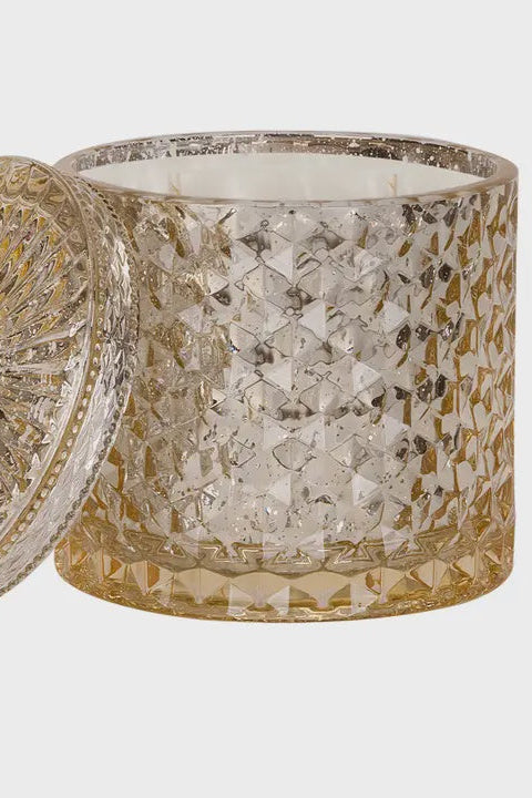 Decorative candle with textured glass container and lid on a white background
