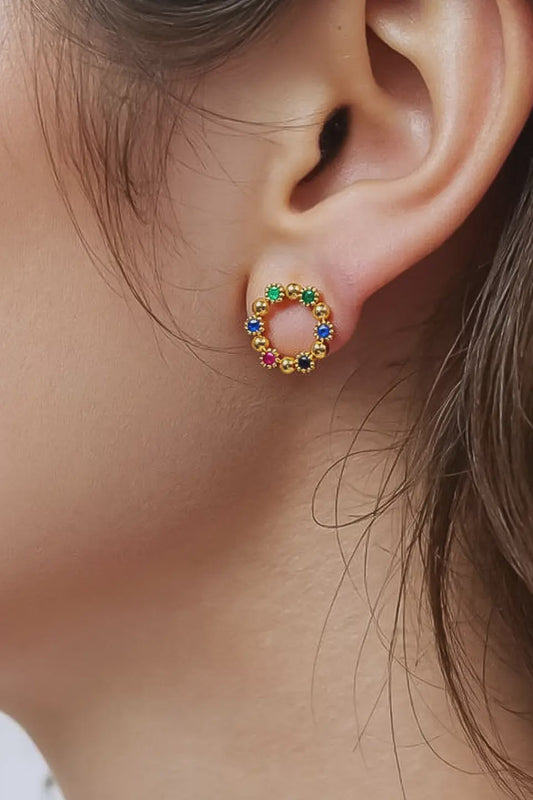 Close-up of an ear wearing a colorful circular earring.