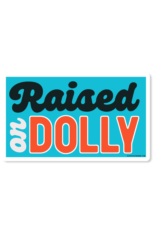 A rectangular sticker with a turquoise background and the phrase 'Raised or DOLLY' in stylized lettering. 'Raised' is in dark navy script, 'or' is in white with a dark navy outline, and 'DOLLY' is in bold orange block letters with a white outline.