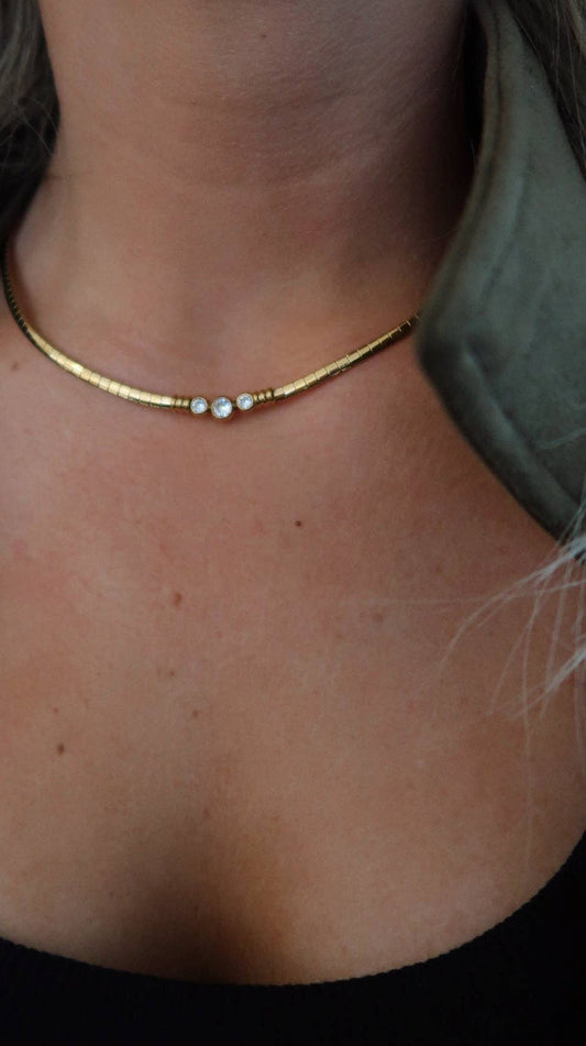 Gold necklace with small pearls worn by a person