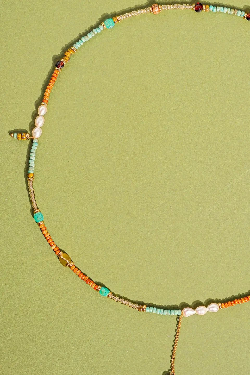 Colorful beaded necklace on a green background