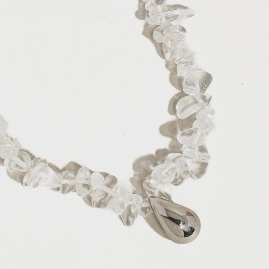 clear crystal necklace with silver teardrop charm at the center
