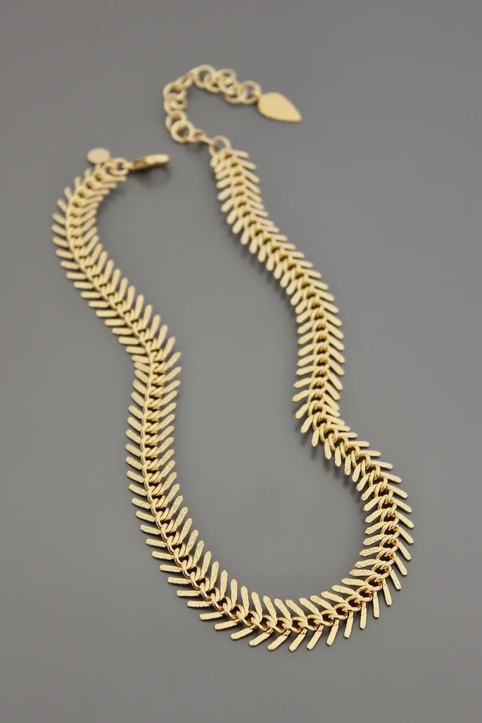 Gold necklace on a gray background