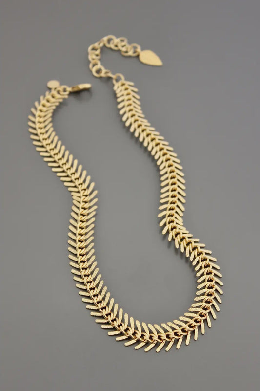 Gold necklace on a gray background