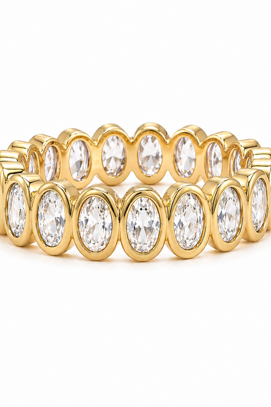 Gold ring with clear gemstones on a white background