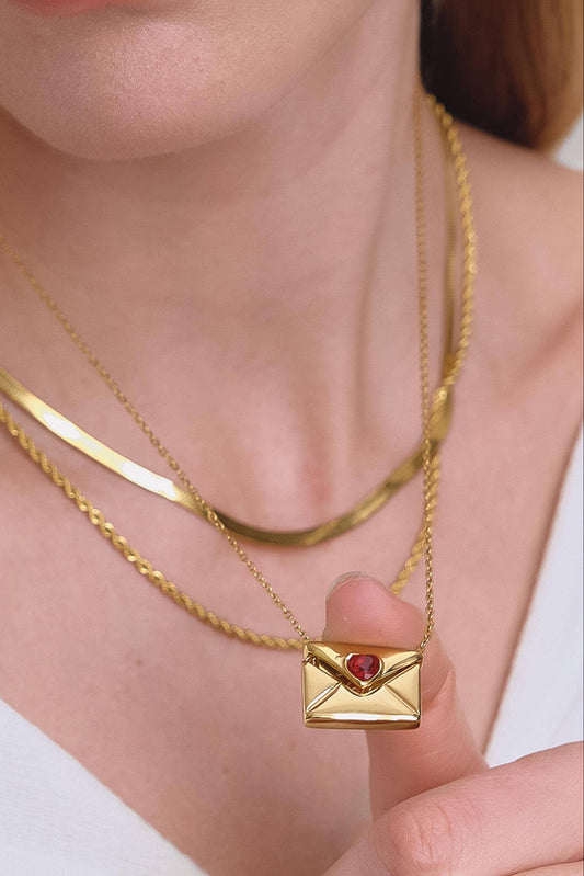 Gold necklace with a heart-shaped pendant worn by a person