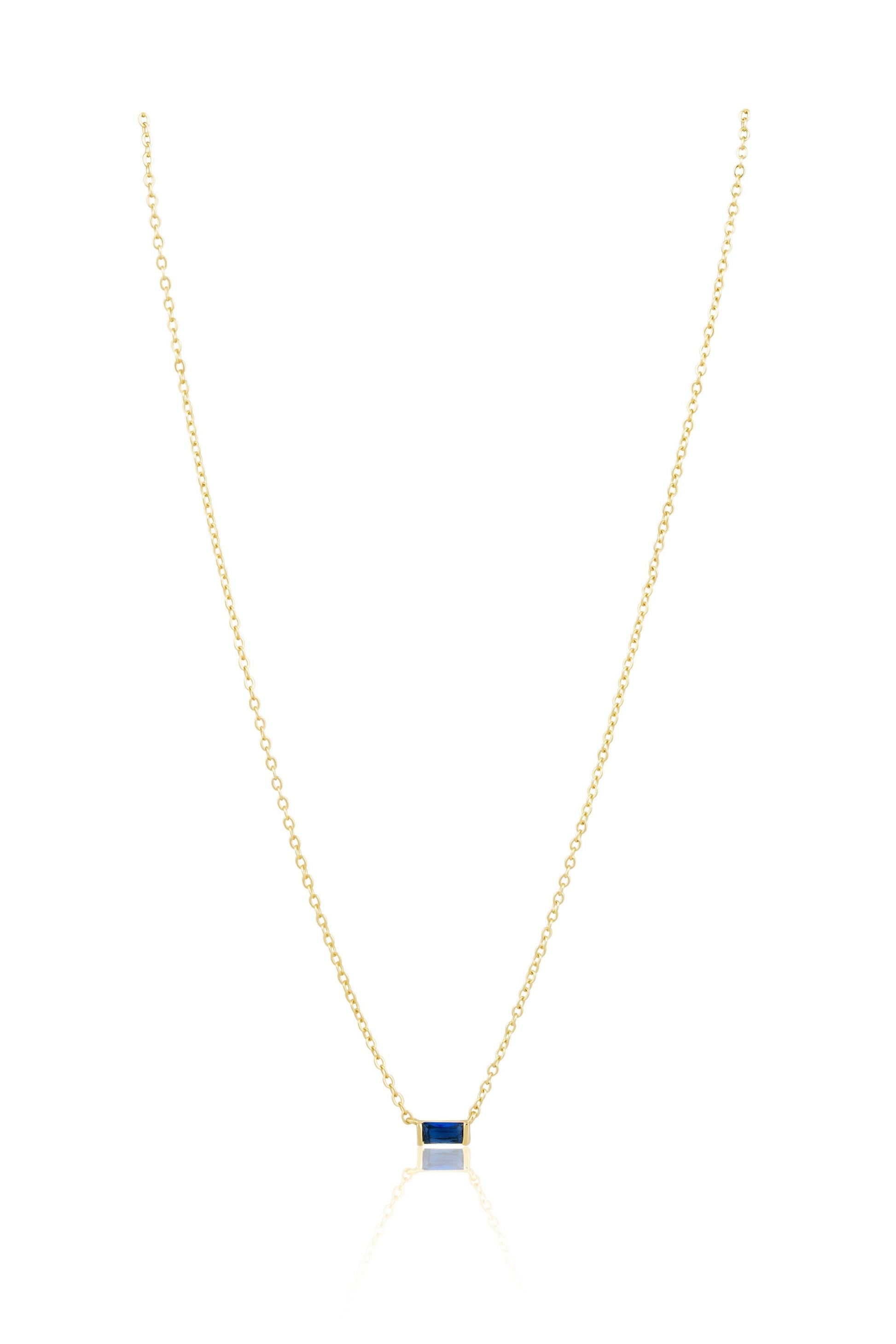 Gold necklace with a square pendant on a white background