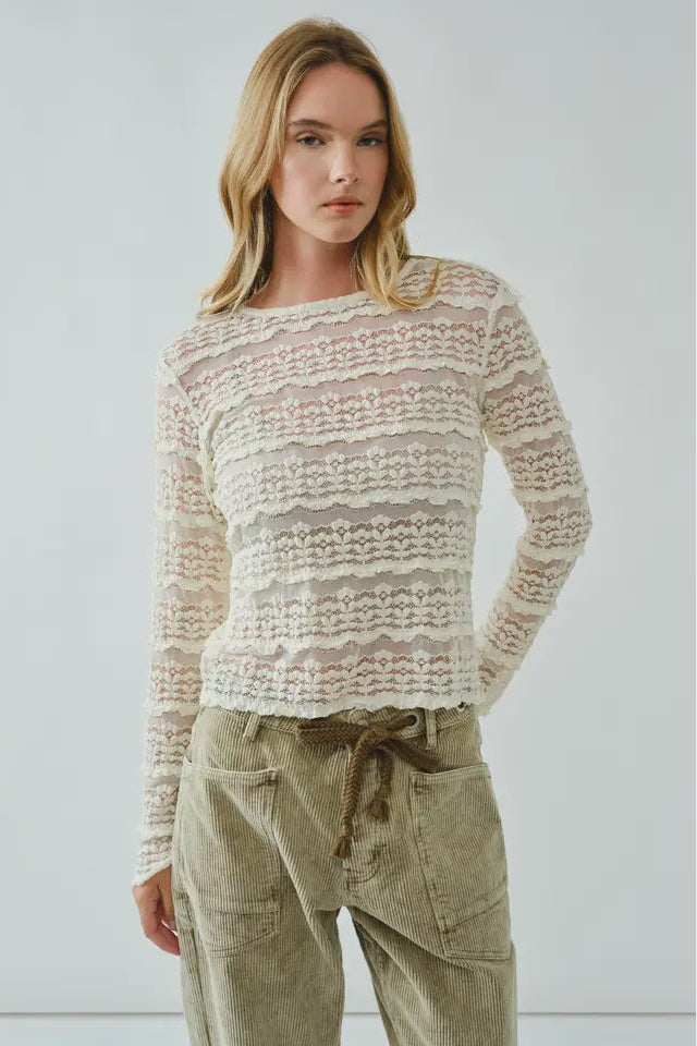 Woman wearing a textured sweater and cargo pants against a plain background