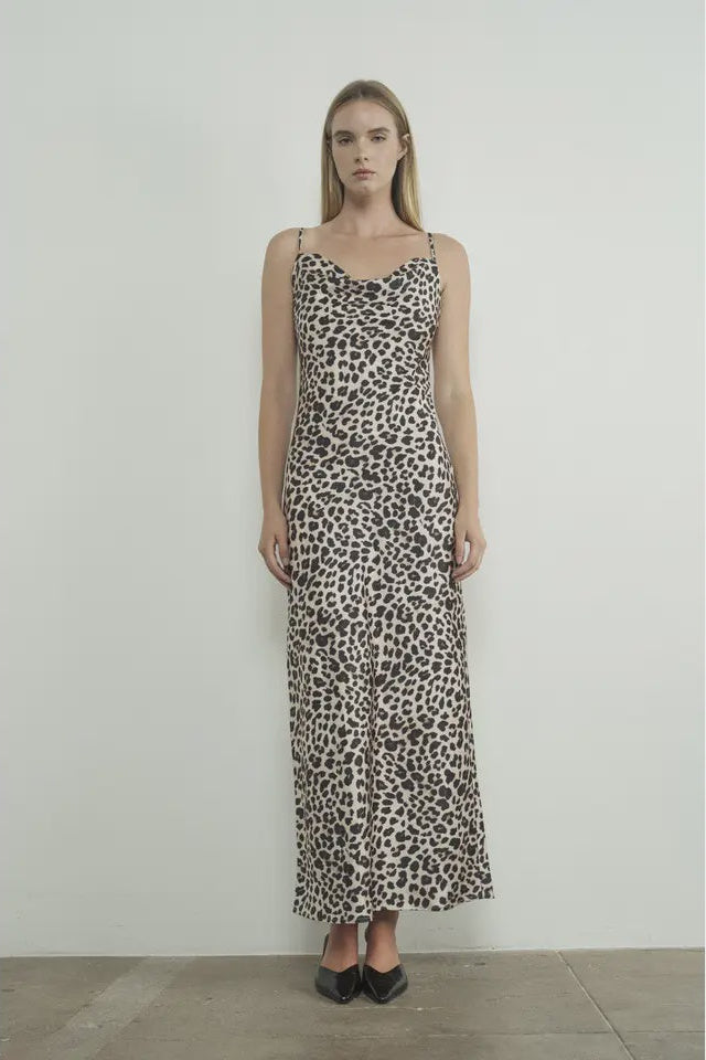 Woman wearing a leopard print dress against a plain background