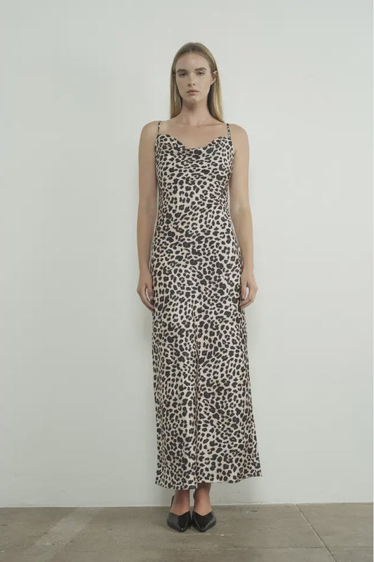 Woman wearing a leopard print dress against a plain background