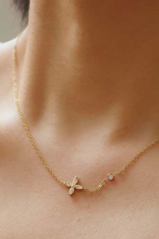 Gold necklace with a butterfly pendant on a person's neck