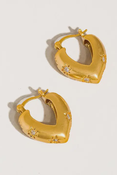 Gold hoop earrings with embedded stones on a light gray background