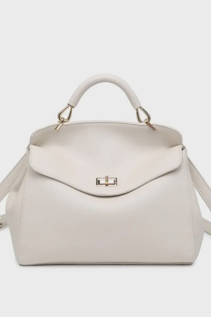White handbag with gold accents on a light gray background