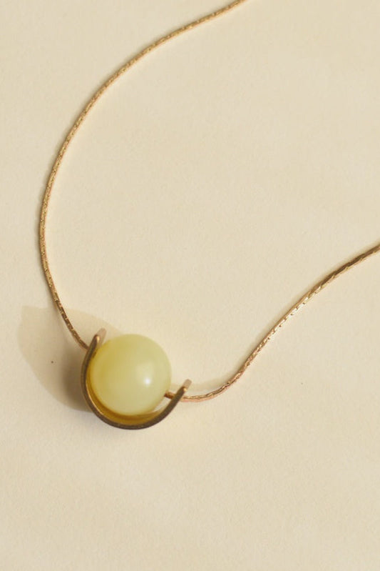 Necklace with a round pendant on a beige background
