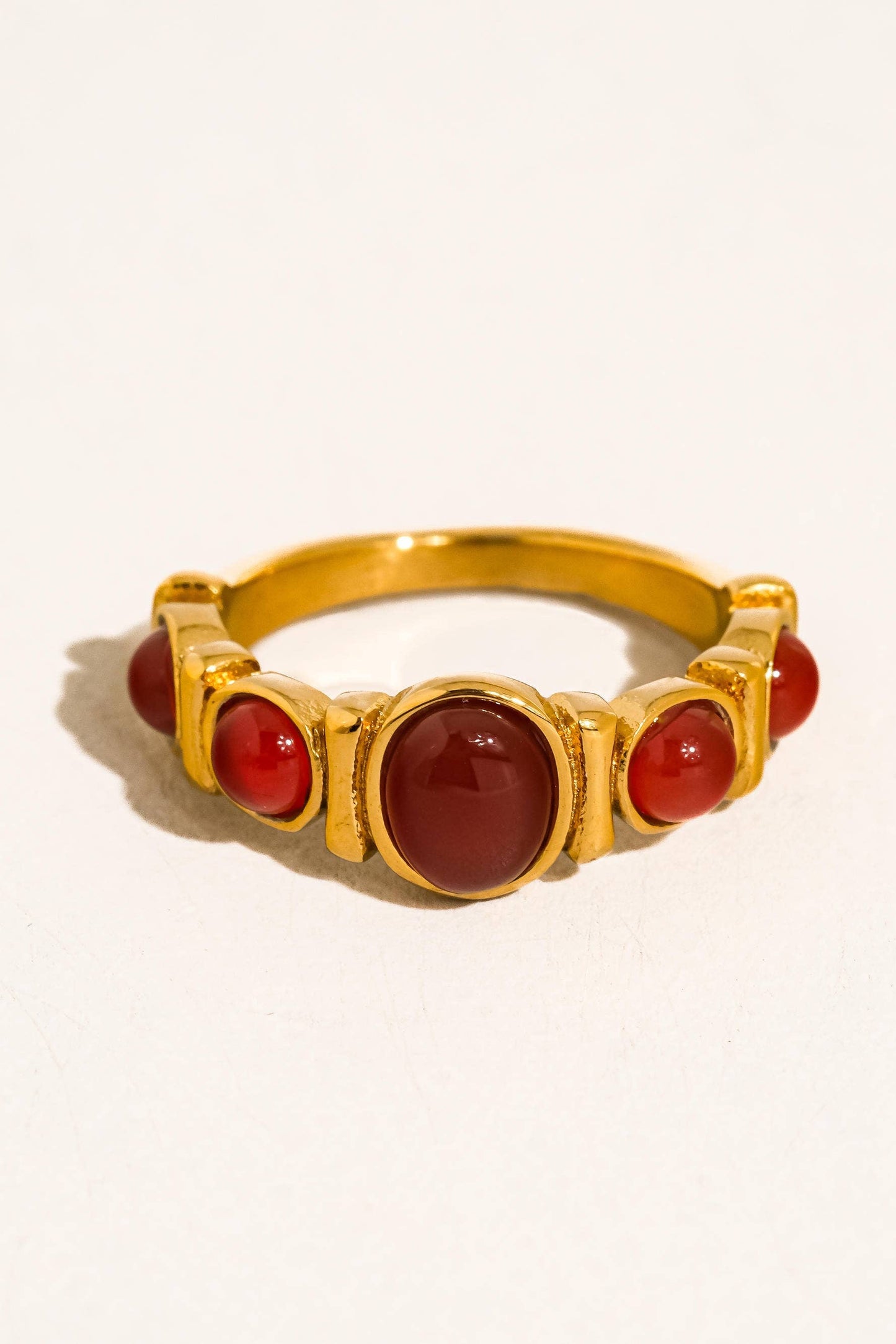 Gold ring with red stones on a white background
