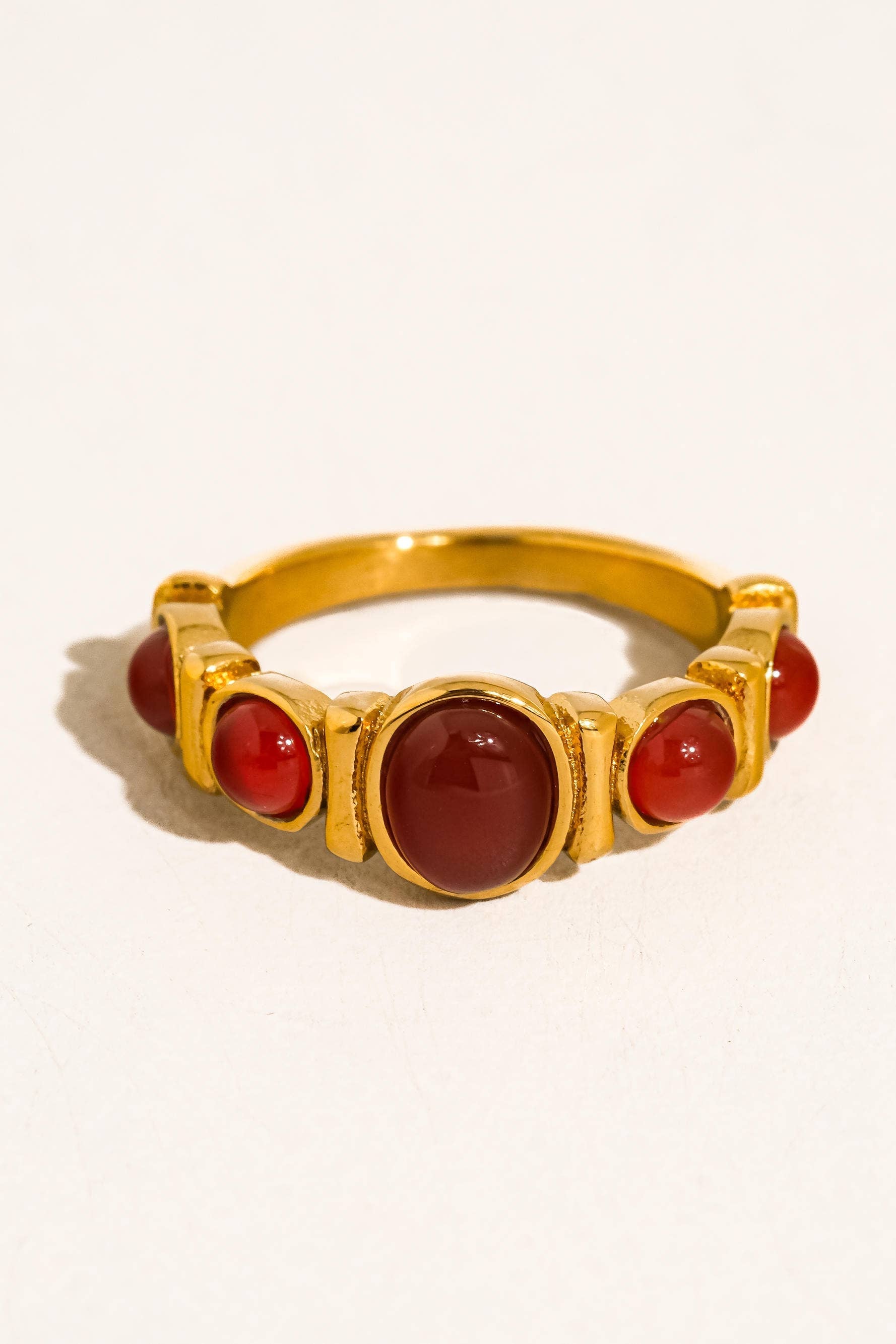 Gold ring with red stones on a white background