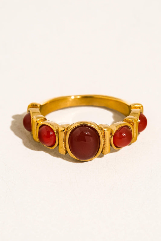 Gold ring with red stones on a white background