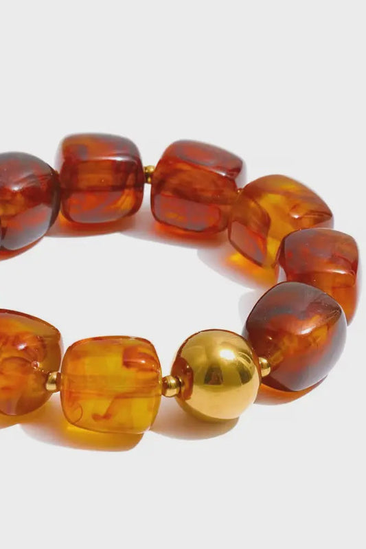 Bracelet with amber-colored beads on a white background