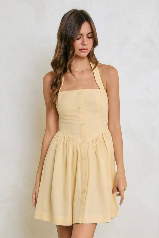 Woman wearing a yellow dress against a plain background