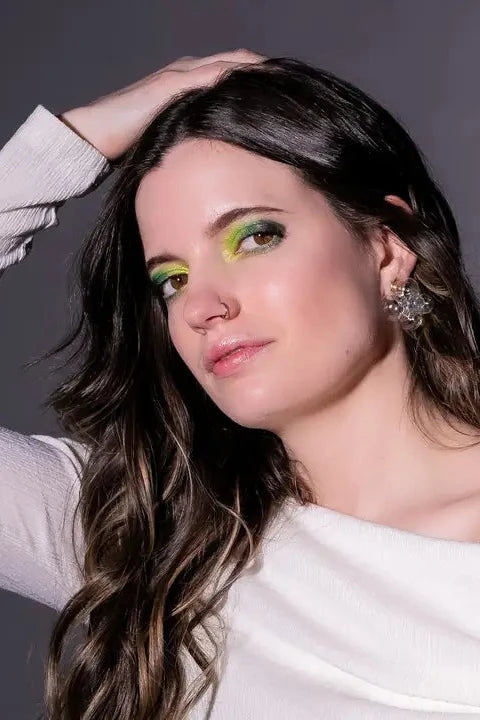 A person with long hair is wearing light blue glass bubble earrings with a gold-colored earring post.