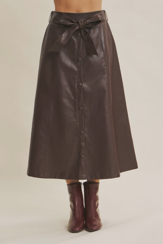 Brown leather skirt with buttons and a belt on a neutral background