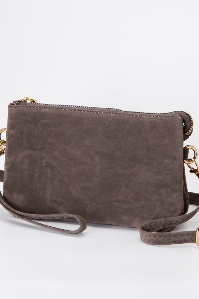 Brown suede handbag with gold accents on a light gray background