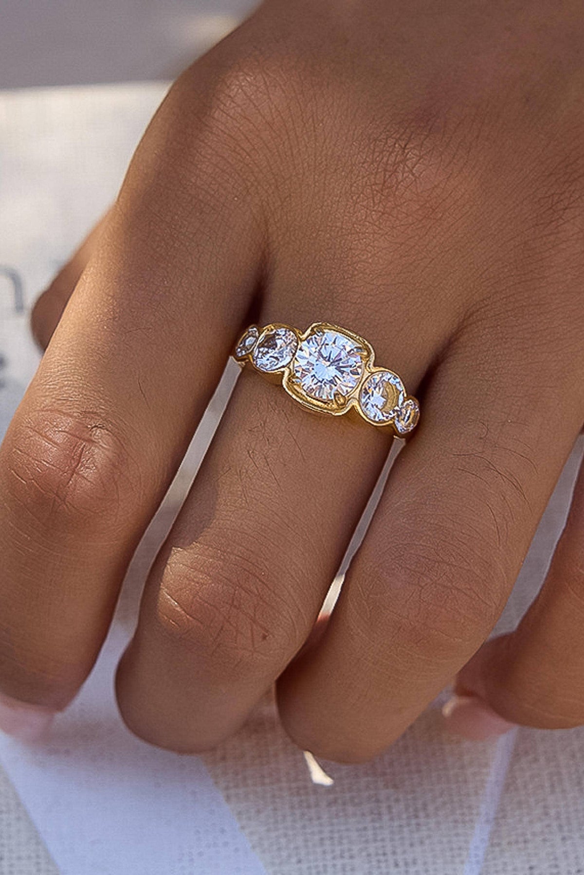 Gold ring with multiple diamonds on a person's finger