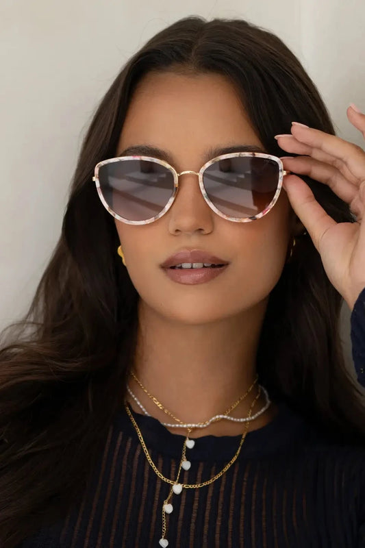 Woman wearing sunglasses with a neutral background