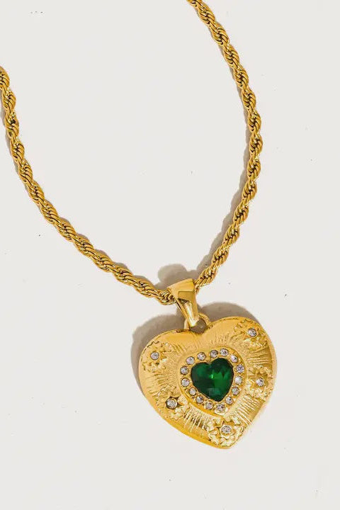 Gold heart-shaped necklace with a green gemstone on a white background