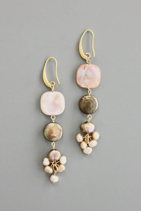 Pair of gold earrings with multicolored stones on a gray background