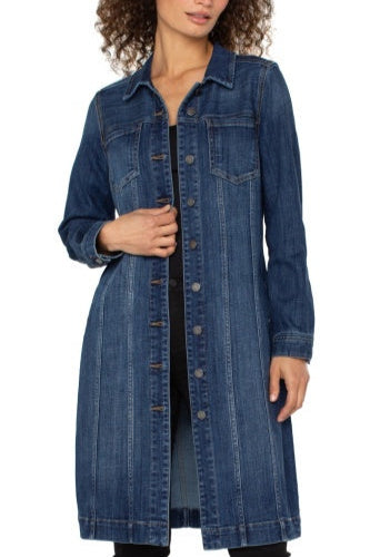 Woman wearing a long denim jacket on a white background